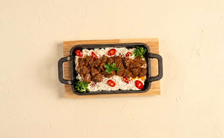 Eggplant tarator with tika at Derian, Yerevan — Smoked eggplant tarator under pieces of beef tika — the cool dip and the hot grill on one plate, which is the point.