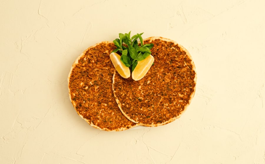 Lahmajoun at Derian, Yerevan — Thin flatbread under spiced minced meat, baked fast — roll it with lemon and herbs and eat it with your hands.